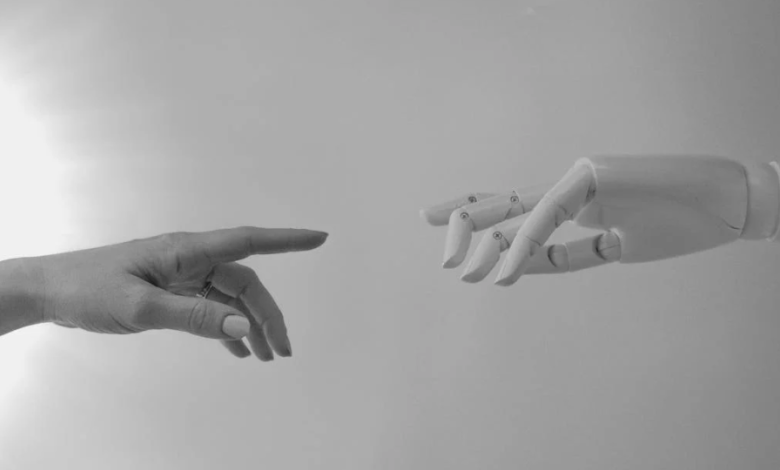 image of a human reaching out touching a robot hand to signify ai chatbot